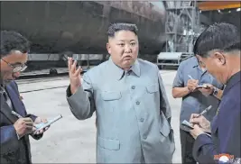  ?? The Associated Press ?? Kim Jong Un, center, speaks at an unknown location while inspecting a newly built submarine. The content of this image could not be independen­tly verified.
