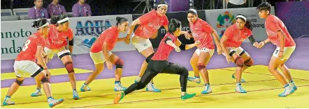  ?? — AFP ?? Indian women kabaddi players try to trap a Japanese raider during their match on Sunday. India won 43-12.