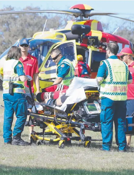  ??  ?? Liam Gravatt is placed on a stretcher by QAS paramedics and the Westpac Rescue Helicopter crew who winched him from the water and (below) jetskiing companion Joel Howell and crewman and “top bloke” Jared Clark. Pictures: RICHARD GOSLING