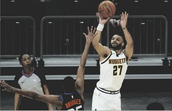 ?? ASSOCIATED PRESS ?? DENVER NUGGETS GUARD JAMAL MURRAY SHOOTS OVER PHOENIX SUNS forward Mikal Bridges (25) during the first half of a game Saturday in Phoenix.