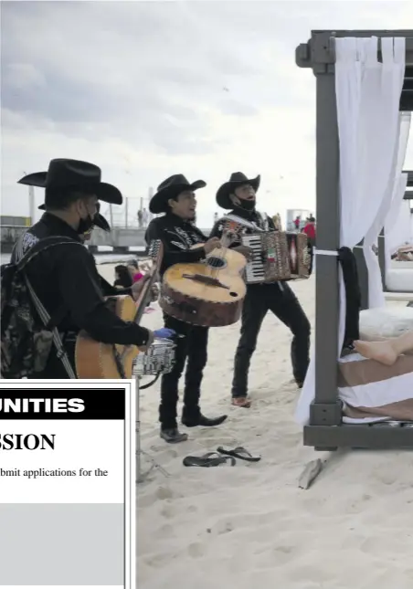  ?? (Photo: AP) ?? Roving musicians “Los Compas” serenade a couple on the shore of Mamitas beach, in Playa del Carmen, Quintana Roo state, Mexico. The country saw a holiday bump in tourism amid the new coronaviru­s pandemic surge.