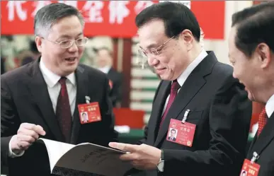  ?? WU ZHIYI / CHINA DAILY ?? Premier Li Keqiang listens to a report from Zhou Hongbo, mayor of Nanning in the Guangxi Zhuang autonomous region, during the Guangxi delegation’s deliberati­on on the Government Work Report on Wednesday, as Peng Qinghua, Guangxi Party chief, looks on.