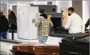  ?? AP ?? Passengers walk next to Nuctech scanners at the Brussels Eurostar train terminal. Some security officials fear China could exploit Nuctech equipment to sabotage transit.