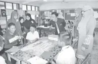  ??  ?? NORDIN (tengah) dan Mahani (dua kanan) melihat murid tahun 6 yang fokus dengan permainan PDPC Bahasa Inggeris yang bertajuk Little Star.