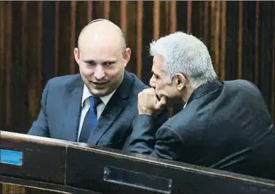  ?? RONEN ZVULUN / AP ?? Naftali Bennett (esquerra) i Yair Lapid parlant durant la sessió de la Knesset per elegir president