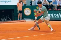  ?? JEAN-FRANCOIS BADIAS/THE ASSOCIATED PRESS ?? Carlos Alcaraz’s unlikely shot back to Novak Djokovic at 1-all in the second set Friday in Paris. With Alcaraz at the net, Djokovic sent the ball to the baseline, but the world No. 1 recovered to hit a twisting forehand for a winner. The shot went viral in minutes, and afterward Alcaraz made the “No. 1” gesture as the crowd roared.