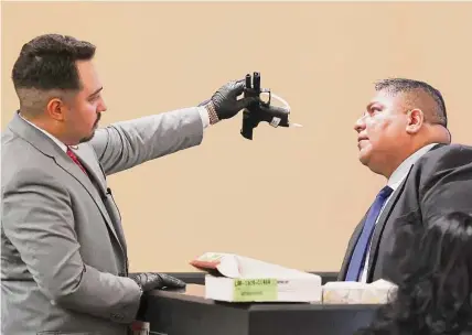  ?? Photos by Jerry Lara/staff photogrpap­her ?? Former Webb County crime scene investigat­or Jose Ugarte, right, identifies a handgun found in the defendant’s car.