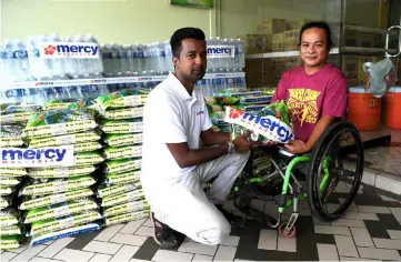  ??  ?? Dr Anbarasu (left) presents the assistance to Francis Xavier. — Bernama photo