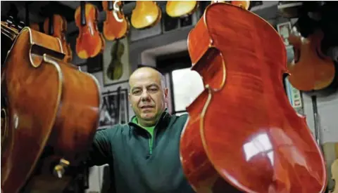  ??  ?? Joaquim Capela carries two cellos at his workshop in Espinho, northern Portugal.
— AFP photos