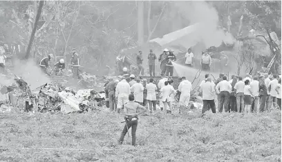  ?? — Gambar AFP ?? BERKECAI: Gambar diambil di tempat kejadian selepas sebuah pesawat Cubana de Aviacion terhempas sejurus ia berlepas dari lapangan terbang Jose Marti di Havana, kelmarin.