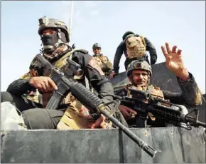  ?? AHMAD AL-RUBAYE/AFP ?? Iraqi forces are seen on Saturday in the centre of the city of Al-Qaim, in Iraq’s western Anbar province, near the Syrian border, after retaking it from Islamic State jihadists a day earlier.