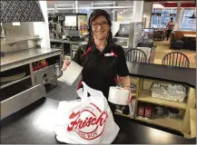  ?? ASSOCIATED PRESS ?? Frisch’s Big Boy employee Nicole Cox bags up an order of toilet paper, among in-demand items including milk and bread.