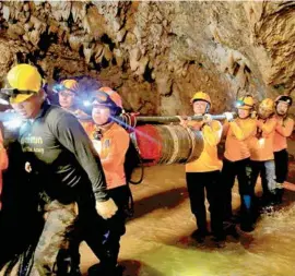  ??  ?? TRABAJO. Rescatista­s retiran el equipo utilizado para sacar a los niños de la cueva.