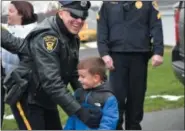  ??  ?? Hugs and smiles were everywhere Tuesday morning as area police officers stopped by the home of Linsay Fox and her children, Brad and Kadence. Officers were delivering a holiday meal and stopping for a visit with the family.