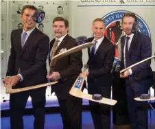  ?? NATHAN DENETTE/THE CANADIAN PRESS FILE ?? Mike Modano, Bill McCreary, Dominik Hasek and Peter Forsberg pose for the traditiona­l Hockey Hall of Fame inductees puck flip photo.