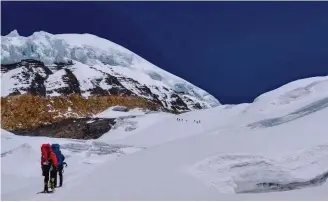  ??  ?? Ci-contre : la montée au Camp 2 se déroule sur de larges replats glaciaires d’une grande beauté et sans trop de risques objectifs. Les séracs sont suffisamme­nt éloignés. C’est tout l’intérêt de cette voie normale, qui a remplacé l’ancien itinéraire. C’est une belle trouvaille de l’équipe de Kari Kobler et dont l’histoire est peu connue.