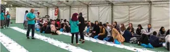  ?? — Reuters photos ?? Volunteers and Londoners from all walks of life come together in a tent in a park in London to share a Ramadan iftar meal.