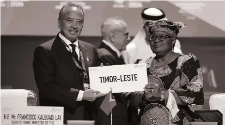  ?? AFP ?? Ngozi Okonjo-Iweala, right, welcomes Francisco Kalbuadi Lay’s Timor-Leste into the WTO in Abu Dhabi yesterday