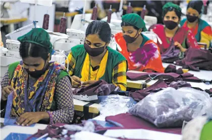  ?? MAHMUD HOSSAIN OPU/ASSOCIATED PRESS ?? Garment employees work in a sewing section of the Snowtex Outerwear Ltd. factory in Savar, Bangladesh, in August. At the Snowtex Outerwear Ltd. factory, the company’s 15,000 workers turn heaps of fabric into clothing sold in countries around the world.