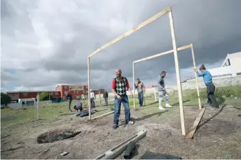  ?? — Reuters file photo ?? People erect a shack during illegal land occupation­s, in Mitchell’s Plain township near Cape Town.