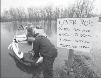  ?? CP PHOTO ?? Rob Dekany, known locally as Uber Rob, ferries stranded passengers at Darlings Island, N.B., on Thursday as the Kennebecas­is River flooded the only road into the community. Dekany has been offering the service all week and refuses to accept any payment.