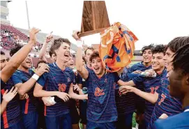  ?? Photos by Eric Christian Smith/Contributo­r ?? Seven Lakes’ Rocco Rascon, center, lifts the championsh­ip trophy after the Spartans’ win over Cinco Ranch in the Region III-6A final at Deer Park.