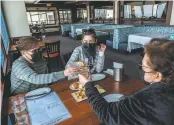  ??  ?? Above: Rica Joson, Nancy Joson and Nikki Gacias raise their glasses at the Fog Harbor Fish House, now reopened inside.