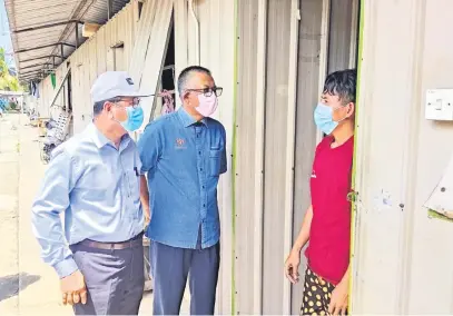  ??  ?? PERIKSA: Isnin (kiri) bersama Pengarah JTK Sabah Wan Zulkifli Wan Setapa (tengah) membuat pemeriksaa­n di salah sebuah lokasi penginapan pekerja kilang.