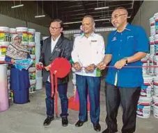  ??  ?? MOHD Anuar (kiri) melakukan simbolik perasmian Bina Paint cawangan Kelantan bersama Rosli (tengah) dan Razani.