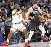  ?? LM Otero Associated Press ?? LeBRON JAMES, guarding Dallas’ Luka Doncic, gritted his way to 26 points with a hurt right foot.