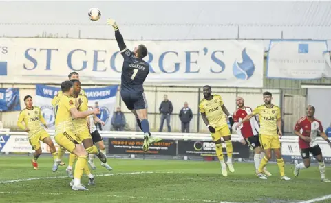  ?? ?? Town keeper Sam Johnson deals with a high ball during the superb win at Woking.