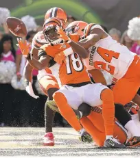  ?? ANDY LYONS/GETTY IMAGES ?? The Bengals’ A.J. Green (18) fends off Browns defenders to catch a Hail Mary pass for a touchdown at the end of the second quarter.