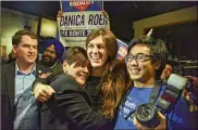  ?? JAHI CHIKWENDIU / THE WASHINGTON POST ?? Danica Roem (center), who ran for the House of Delegates against GOP incumbent Robert Marshall, is greeted by supporters as she prepares to give her victory speech in Manassas, Va.