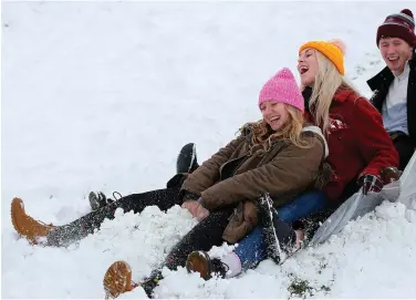  ??  ?? Above: People sledding in the snow in Jackson’s Fields in Rochester in the UK yesterday. Photo: Getty