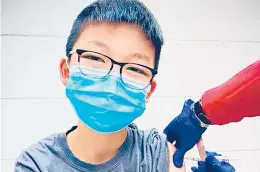  ?? RICHARD CHUNG 2020 ?? Caleb Chung is given his first dose of the Pfizer vaccine or placebo Dec. 22 as a trial participan­t for kids ages 12 to 15 at Duke University Health System in North Carolina.
