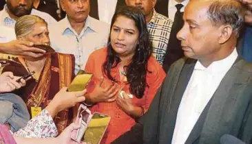  ?? PIC FILE ?? M. Indira Gandhi (centre) at a press conference at the Federal Court in January.