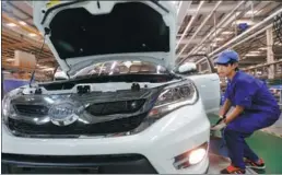  ?? REUTERS ?? An employee puts the finishing touches to a car at a BYD assembly line in Shenzhen, Guangdong province. The firm said it expects sales to rebound in the fourth quarter of this year.
