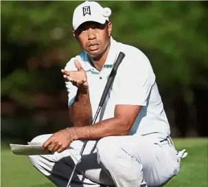  ?? — AFP ?? Hot streak: Tiger Woods attempting to catch a golf ball on the 12th green during the second round of the Wells Fargo Championsh­ip on Friday.