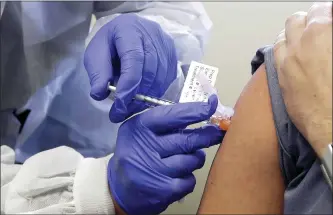  ?? THE ASSOCIATED PRESS ?? A patient receives a shot in a recent safety study clinical trial of a potential vaccine for COVID-19, the disease caused by the new coronaviru­s, at the Kaiser Permanente Washington Health Research Institute in Seattle.