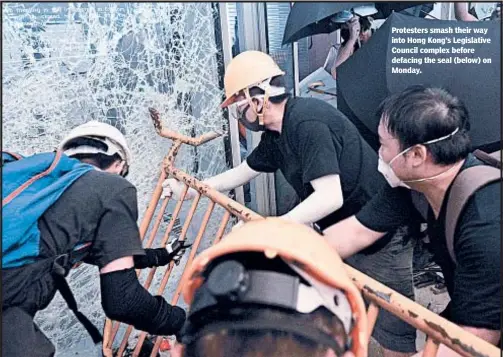  ??  ?? Protesters smash their way into Hong Kong’s Legislativ­e Council complex before defacing the seal (below) on Monday.