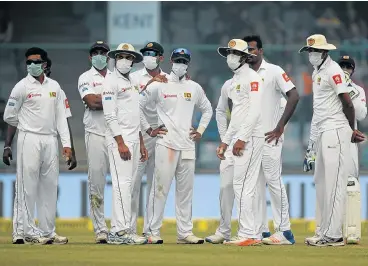  ?? /AFP ?? Smog control: Sri Lankan cricket players wear masks to protect themselves from pollution on the second day of the third Test against India at the Feroz Shah Kotla Cricket Stadium in New Delhi.
