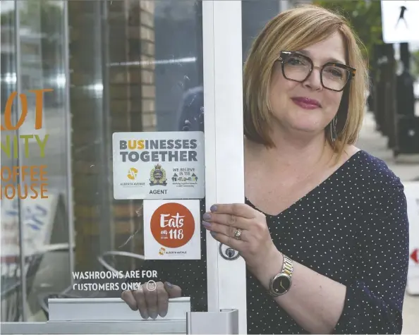  ?? Ed Kaiser ?? Christy Morin, general manager of The Carrot Community Arts Coffeehous­e, shows a Businesses Together sign, which has been distribute­d to Alberta Avenue establishm­ents. “It’s a little bit of a reminder that we don’t tolerate wrongful behaviour,” she says.