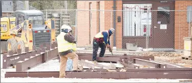  ?? (NWA Democrat-Gazette/Mike Eckels) ?? Workers sort out pieces of a steel support structure as they get ready to attach them to a crane. These pieces make up the framework of the new Decatur High School cafeteria, which is part of the high school renovation project which began in September 2020.