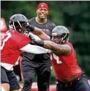  ?? CURTIS COMPTON / CCOMPTON@AJC.COM ?? Falcons rookie defensive tackle Deadrin Senat (right) works against defensive lineman Garrison Smith during mandatory mini-camp last month in Flowery Branch.