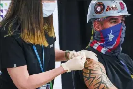  ?? MARY ALTAFFER, POOL ?? Northwell Health nurse inoculates Local 28Sheet Metal Worker Demetrius Buttelman with the first dose of the Pfizer vaccine during a news conference at the Belmont Park in Elmont, N.Y. The United States opened more distance between itself and much of the rest of the world on Thursday, April 15, nearing the 200million­th vaccine administer­ed in a months-long race to protect the population against COVID-19, even as other countries, rich and poor, struggle with stubbornly high infection rates and deaths.