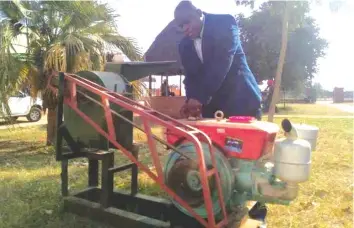  ??  ?? Cde Porusingaz­i gets a feel of one of the grinding mills he is giving out to winners in ward based weekly football competitio­ns in his constituen­cy.