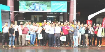  ??  ?? Ling (front row, 10th left), flanked by Tan on his left and Ting, with other staff members and customers during a photo-call at the roadshow in Miri.