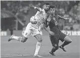  ?? MANU FERNANDEZ/AP ?? Iran’s Ramin Rezaeian, left, challenges Christian Pulisic of the United States during a World Cup Group B match Tuesday at the Al Thumama Stadium in Doha, Qatar.