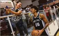  ?? Josie Norris / Houston Chronicle ?? Reyna Gomez of Uvalde shares a laugh with the San Antonio Spurs’ Dominick Barlow during a practice held at Uvalde High School on Saturday.