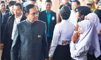  ?? — AFP photo ?? Thai Prime Minister Prayut (left) arrives at Princess of Naradhiwas University in Thailand’s southern province of Narathiwat to hold a cabinet meeting.